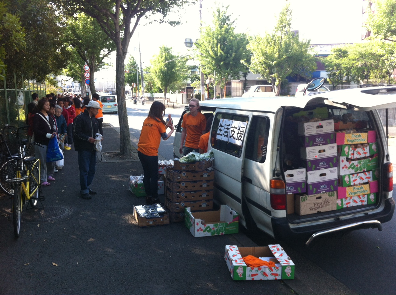 hundreds line up in Kyoto Japan to receive food donations from Kozmoz