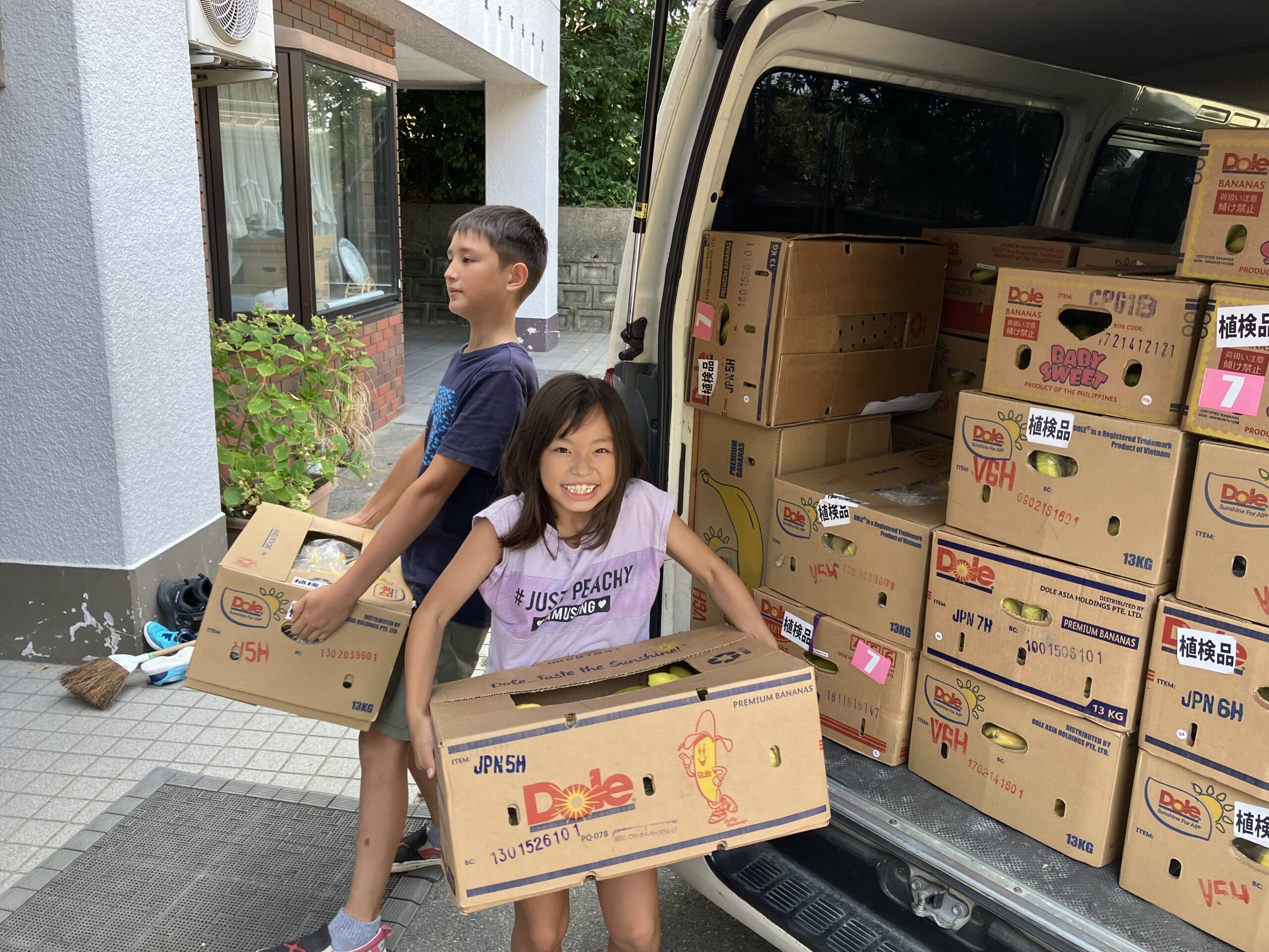 Happy young Kozmoz Food Bank volunteers at Kansai Children's Home distributing food
